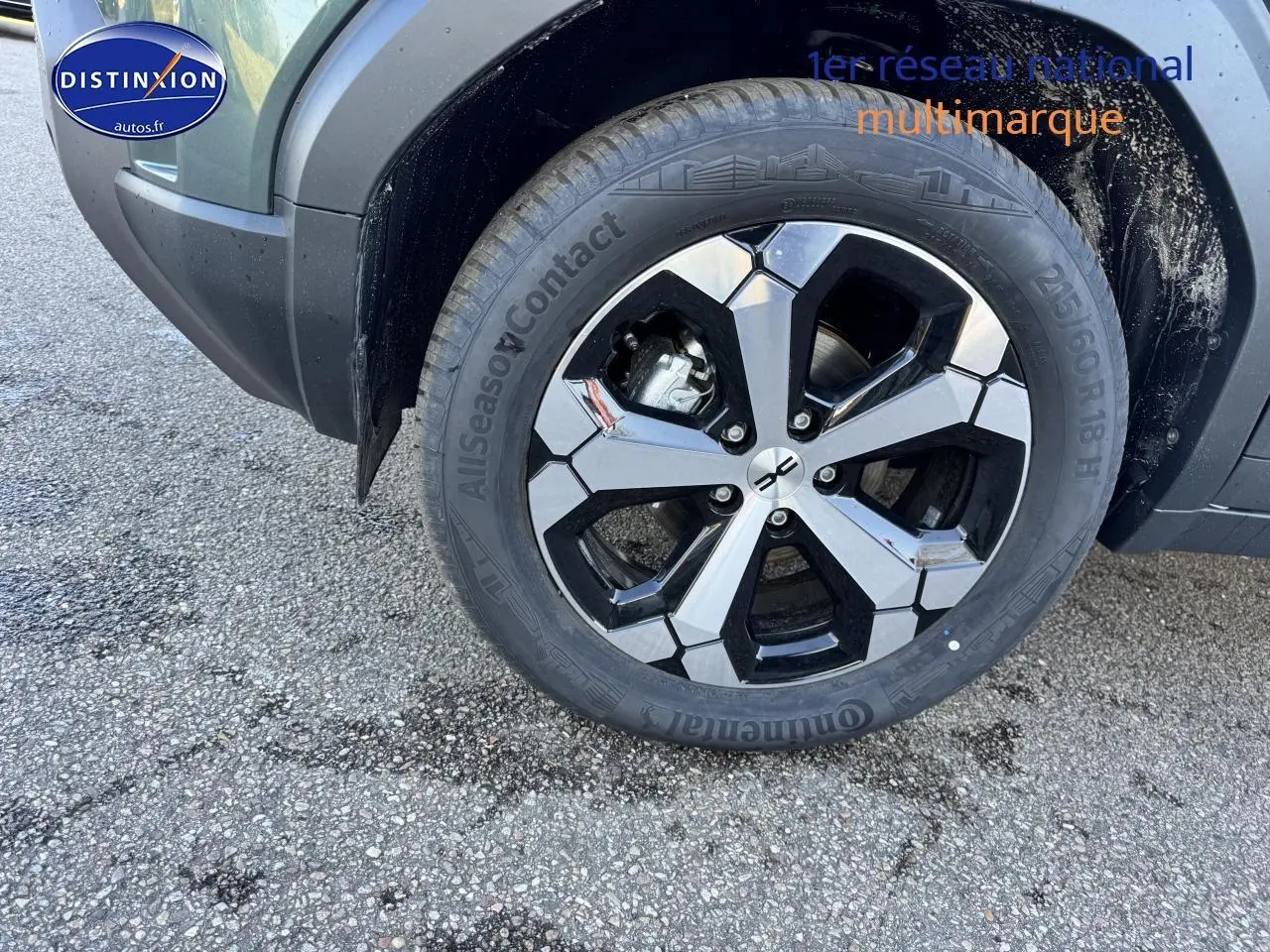 Gros plan sur la roue avant droite du Dacia Duster vert cèdre, jante alu bicolore et pneu Continental.