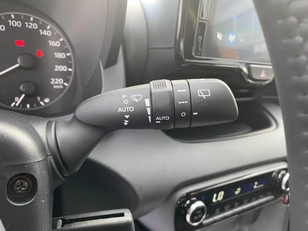 Gros plan sur la commande d'essuie-glace à gauche du volant dans l'habitacle d'une Toyota Yaris hybride 2025.