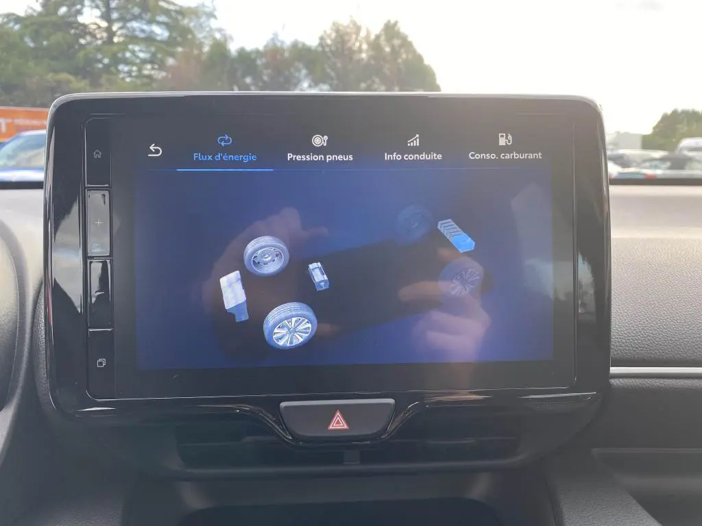 Écran tactile central de la Toyota Yaris 2025 montrant le flux d'énergie hybride, intérieur sobre et moderne.