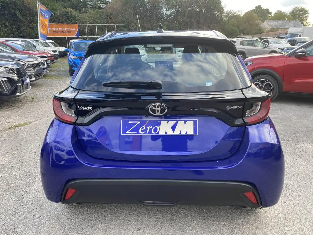 Vue arrière d'une Toyota Yaris hybride 2025 en bleu Genièvre avec toit noir et feux arrière distinctifs.