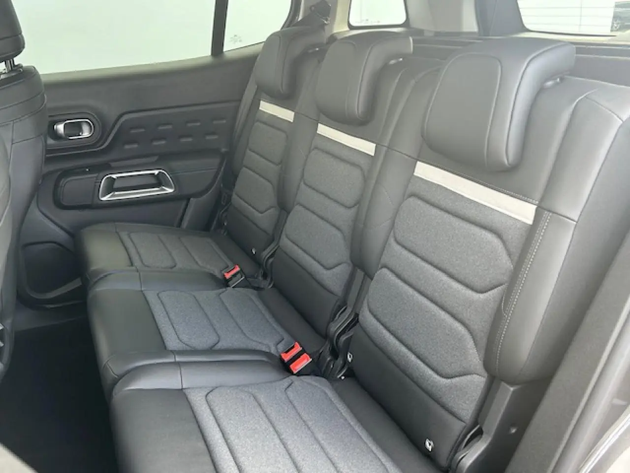 Vue intérieure des trois sièges arrière indépendants en cuir et tissu gris du Citroën C5 Aircross 2025.