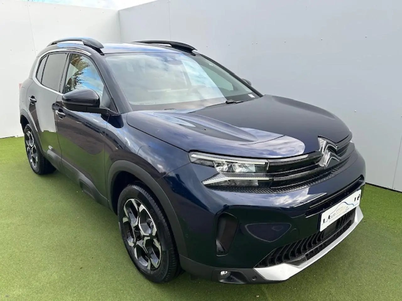 Vue 3/4 avant gauche d'un Citroën C5 Aircross bleu Eclipse métallisé avec calandre noir brillant et jantes diamantées.