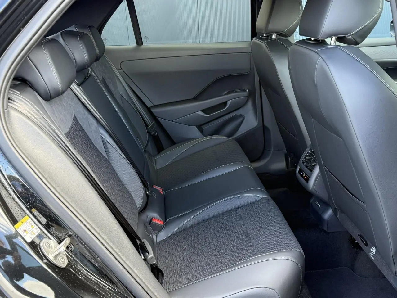 Vue latérale gauche de l’intérieur arrière noir avec sièges en tissu et cuir du Volkswagen T-Roc 2026 R-Line.