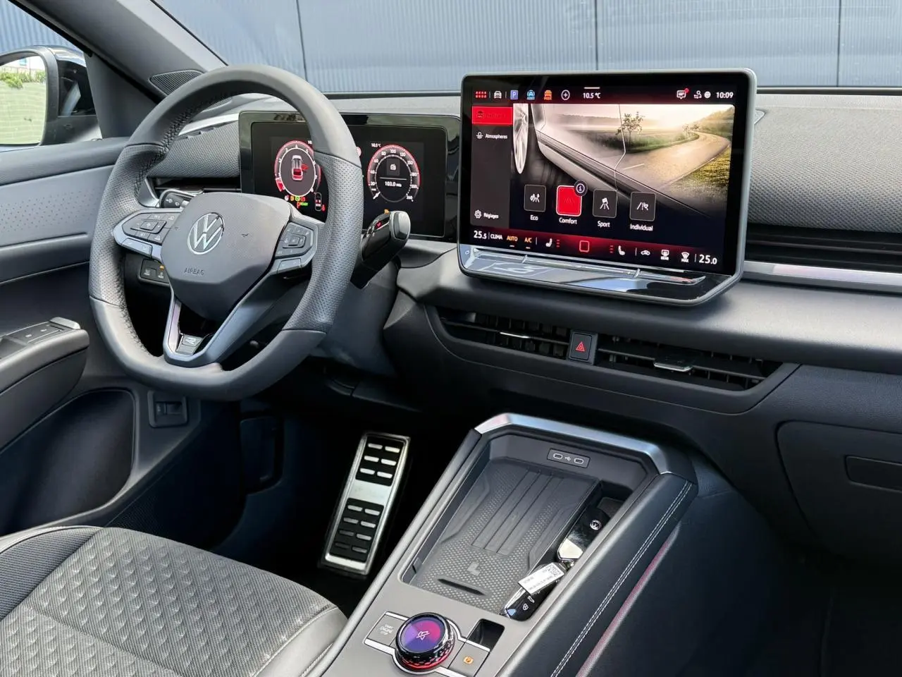 Vue intérieure côté conducteur du Volkswagen T-Roc 2026, tableau de bord numérique et écran tactile central avec volant cuir multifonction.