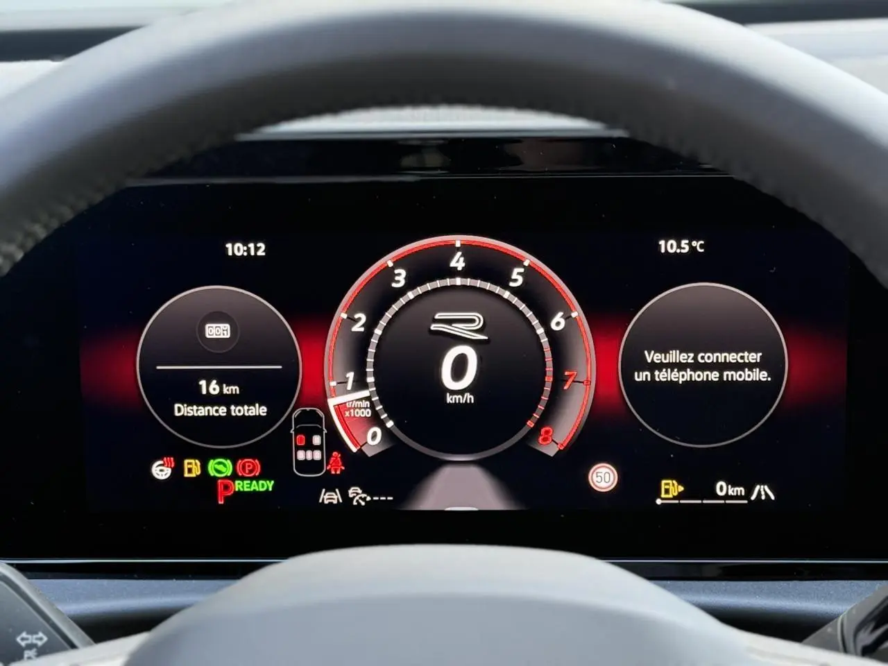 Vue rapprochée du tableau de bord numérique du Volkswagen T-Roc 2026, affichage noir avec compte-tours rouge et informations de conduite.