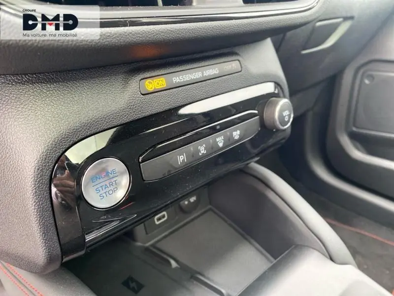 Détail de la console centrale noire du Ford Kuga 2026 avec bouton start/stop et commandes audio.