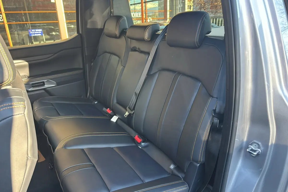 Vue intérieure côté droit sur la banquette arrière en cuir noir avec surpiqûres jaunes du Ford Ranger Wildtrak Plus gris iconic 2026.