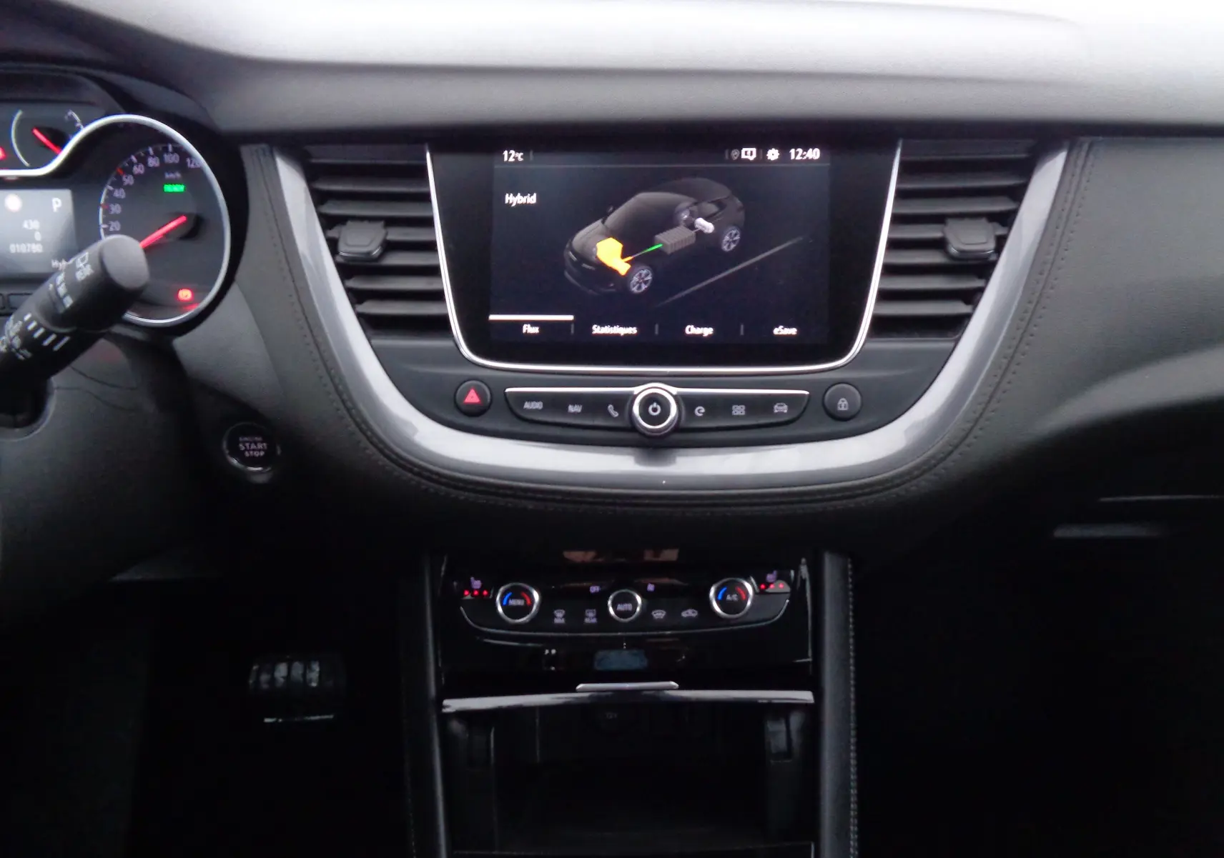 Tableau de bord noir de l'Opel Grandland X hybride 2021 avec écran tactile affichant le mode hybride.