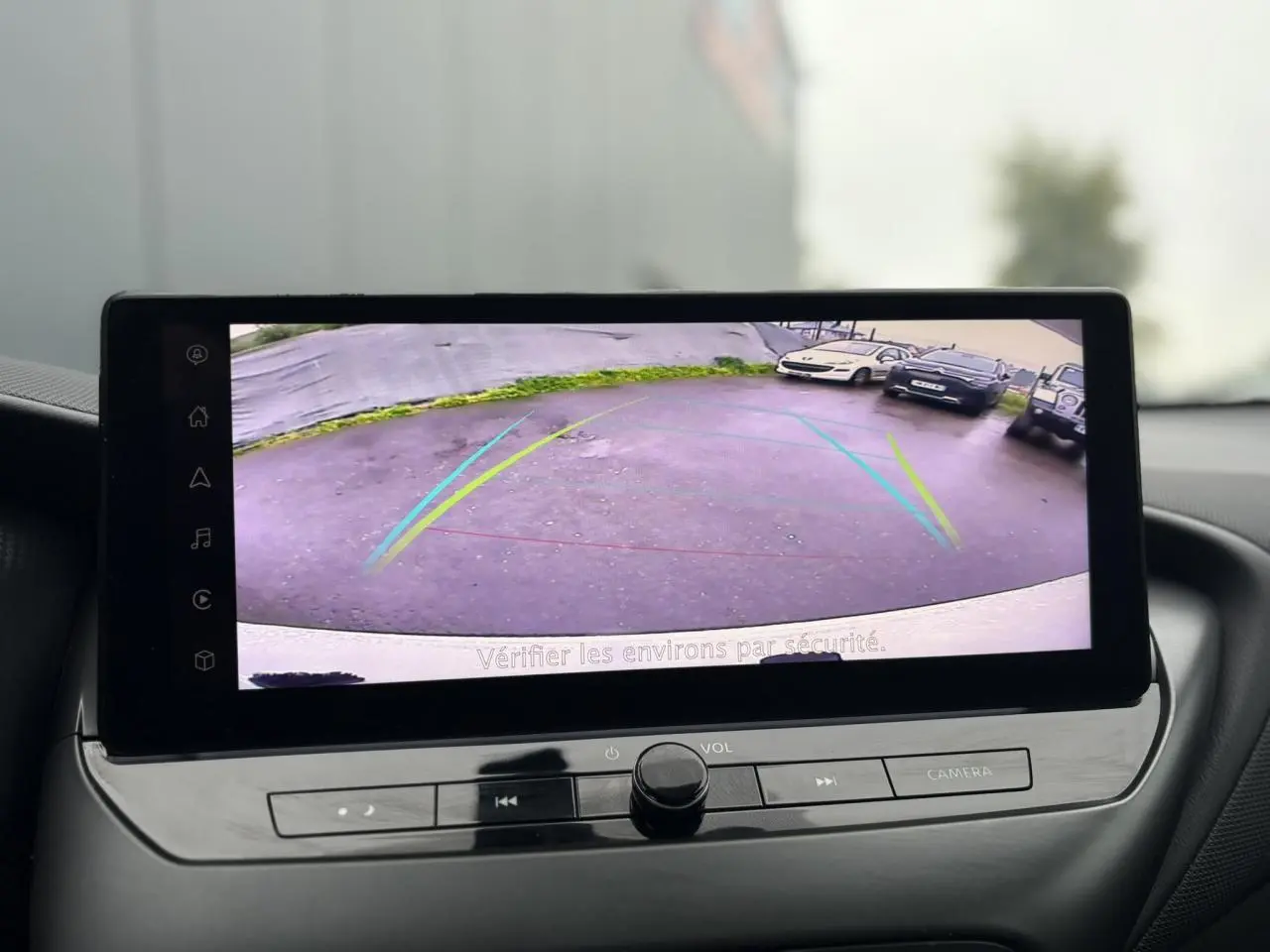 Écran tactile du Nissan Juke 2025 montrant la caméra de recul avec lignes de guidage colorées.