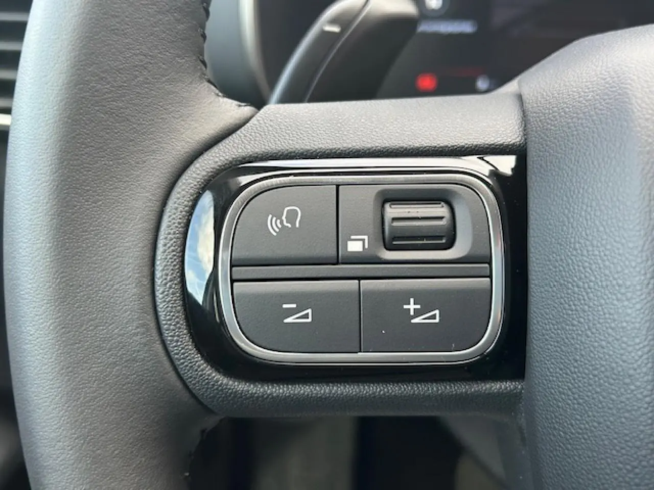 Gros plan sur les commandes du volant en cuir du Citroën C5 Aircross gris platinium 2025, boutons multifonctions.