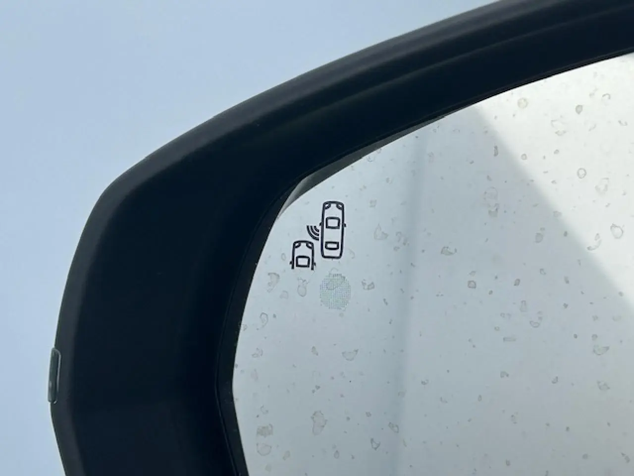 Gros plan sur le rétroviseur extérieur noir brillant du Citroën C5 Aircross gris platinium avec icône d'alerte d'angle mort.