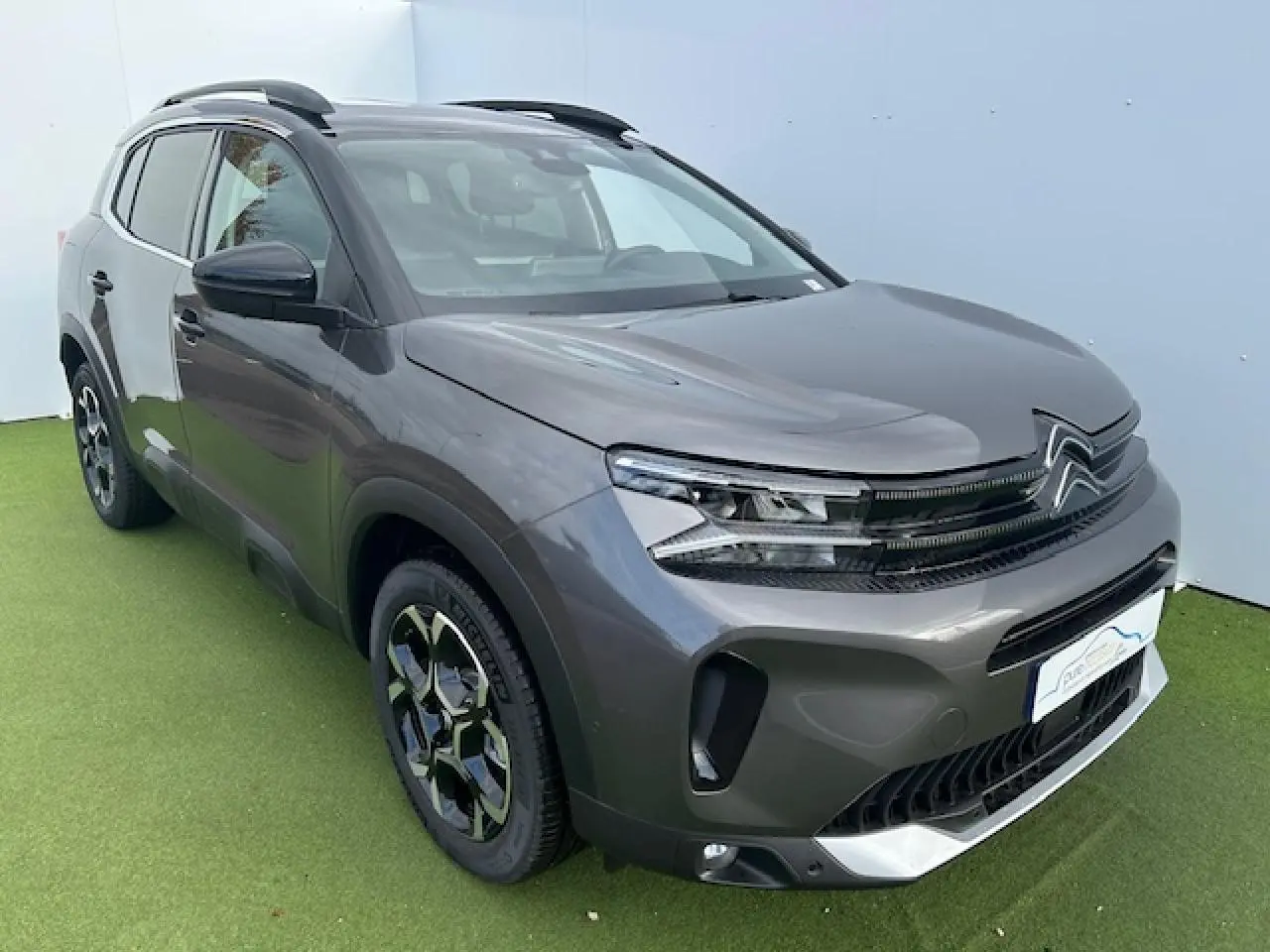 Citroën C5 Aircross gris platinium métal en 3/4 avant droit avec calandre noir brillant et jantes diamantées bi-ton.