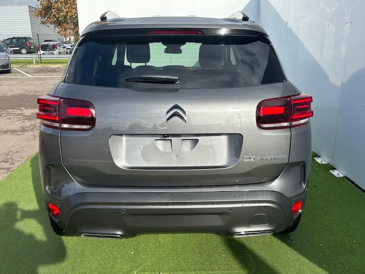 Vue arrière d'un Citroën C5 Aircross gris platinium métallisé avec feux 3D à LED et double sortie d'échappement chromée.