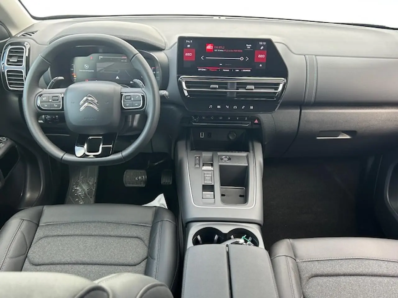 Intérieur avant du Citroën C5 Aircross 2025, tableau de bord moderne avec écran tactile et volant cuir gris.