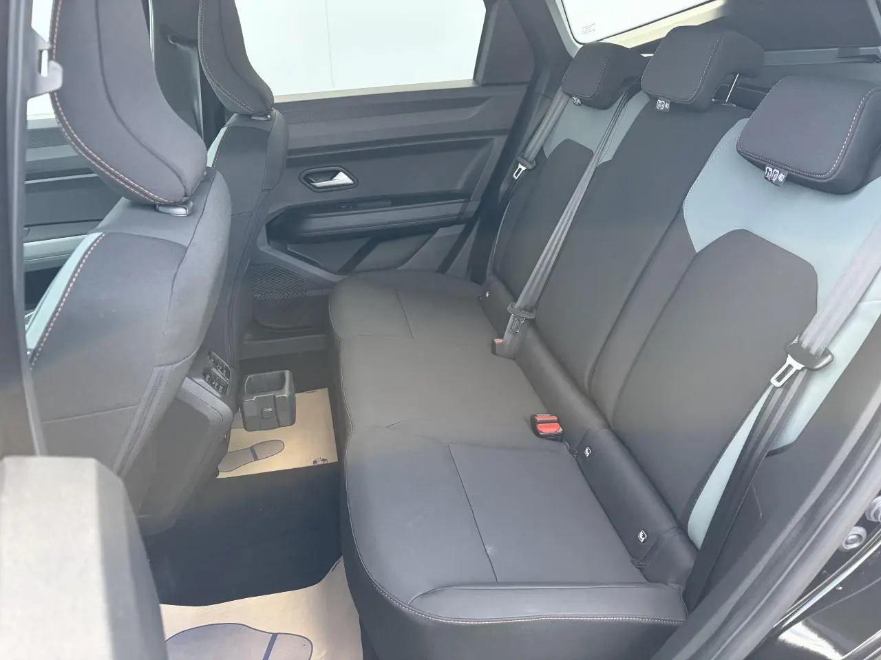 Vue latérale intérieure sur la banquette arrière noire du Dacia Bigster 2026 avec appuie-têtes et ceintures visibles.