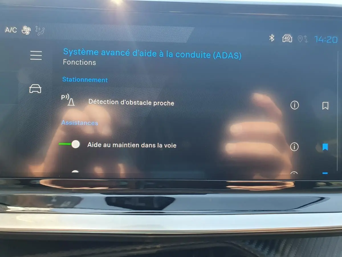 Écran tactile intérieur affichant le système avancé d’aide à la conduite du Peugeot 208 gris Artense, vue de face.