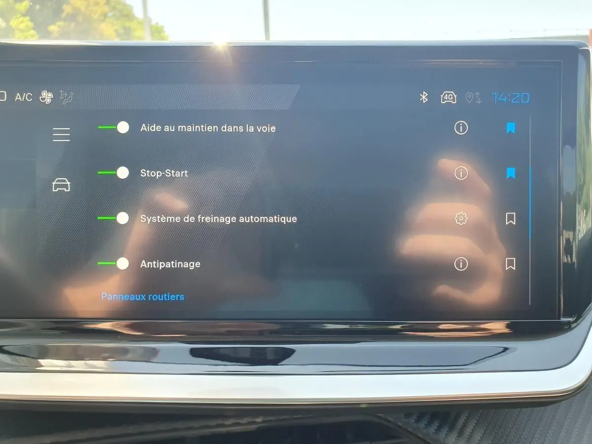 Écran tactile intérieur de la Peugeot 208 1.2 Hybrid 110 Allure affichant les aides à la conduite activées.