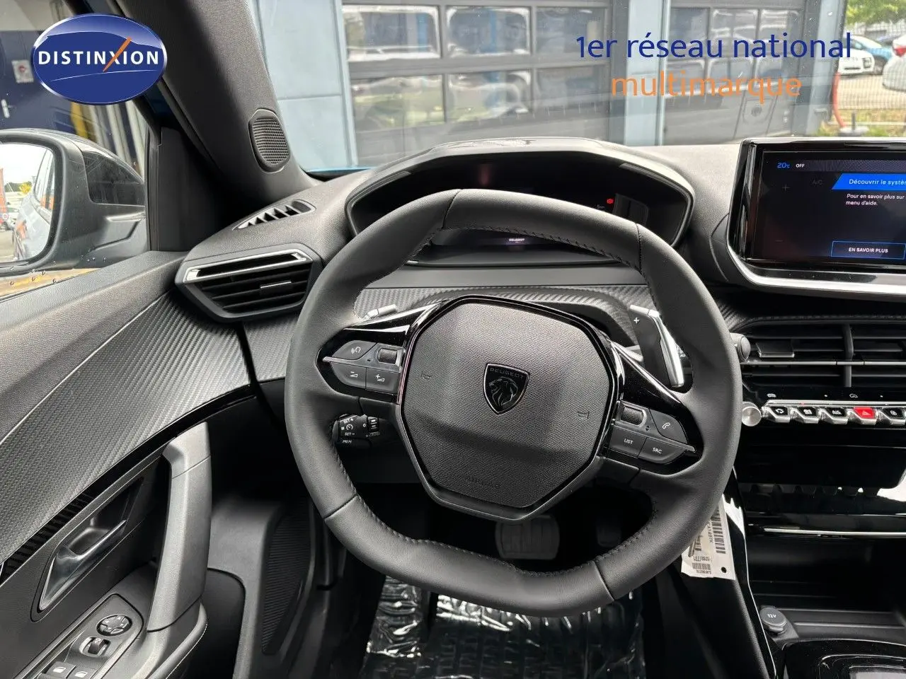 Vue rapprochée du volant cuir noir et tableau de bord moderne du Peugeot 2008 Hybrid 2025, ambiance intérieure soignée.