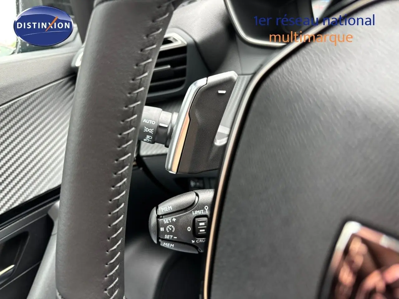 Gros plan sur le volant et les commandes de régulateur de vitesse du Peugeot 2008 Hybrid 136ch finition Allure.