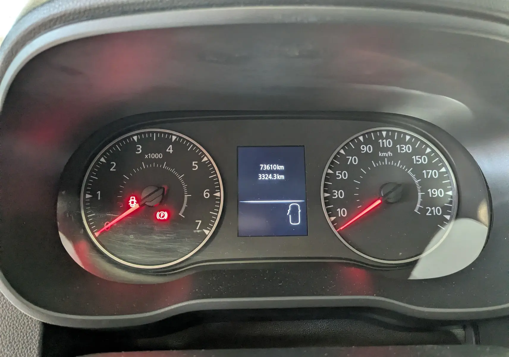 Vue rapprochée du tableau de bord du Dacia Duster gris 2023, affichant le compteur de vitesse et le compte-tours.