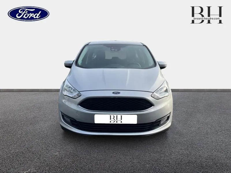 Vue avant frontale d'une Ford C-MAX gris lunaire 2018 avec calandre noire et phares halogènes allumés.