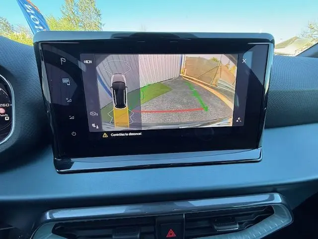 Écran central du tableau de bord montrant la caméra de recul active du SEAT Arona noir avec guidage de trajectoire.