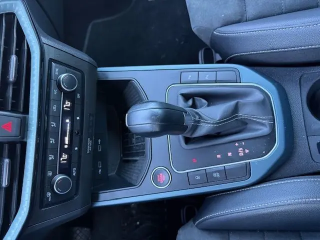 Vue rapprochée de la console centrale du SEAT Arona 2022 noir, mettant en valeur le levier de boîte automatique et les commandes environnantes.