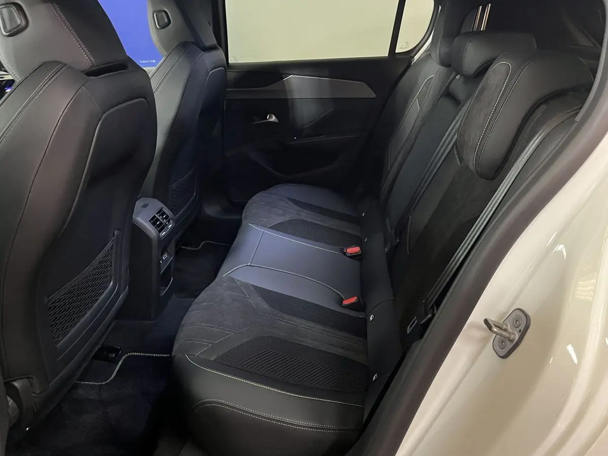 Vue latérale des sièges arrière en cuir noir avec surpiqûres blanches du Peugeot 308 GT PHEV blanc nacré 2022.