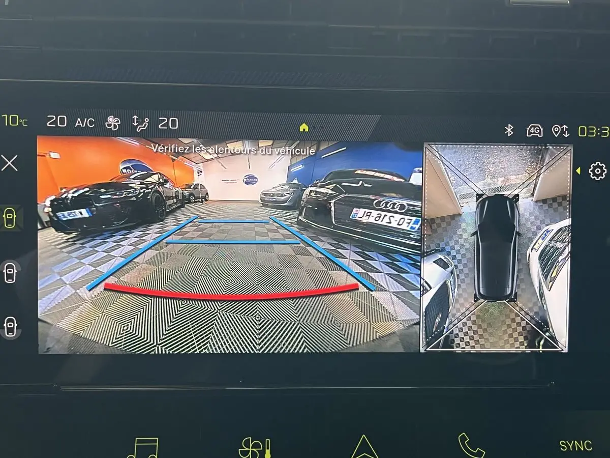 Affichage caméra 360° et recul montrant un parking intérieur avec plusieurs voitures, vue arrière du véhicule en stationnement.