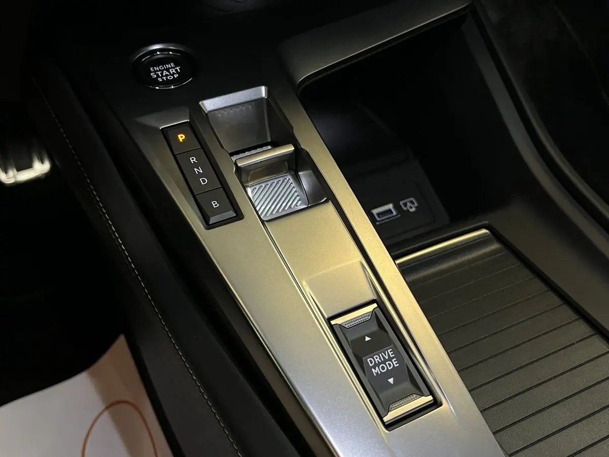 Gros plan sur la console centrale de la Peugeot 308 GT PHEV 180 EAT8 avec levier de vitesses et bouton Drive Mode.