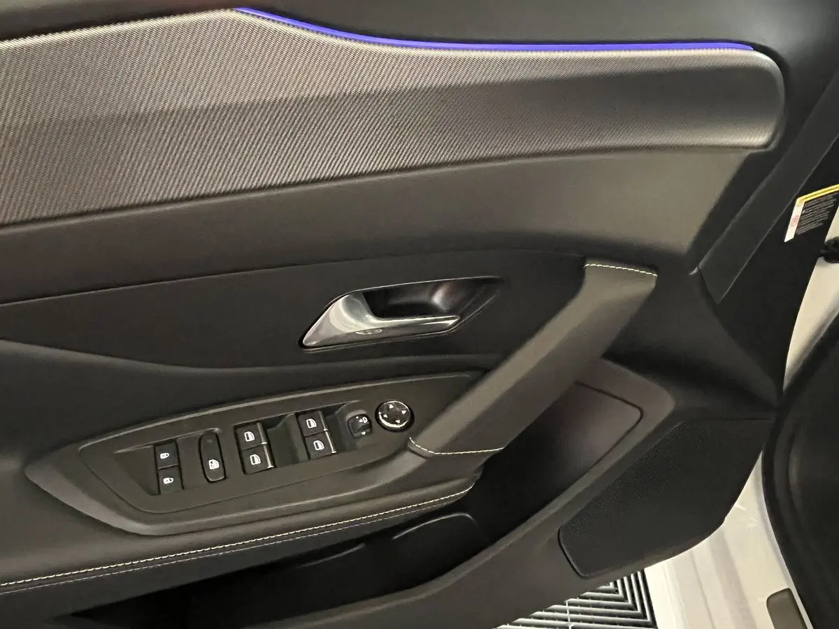 Intérieur côté gauche de la porte PEUGEOT 308 GT PHEV 2022, garniture noire avec surpiqûres blanches et commandes électriques.