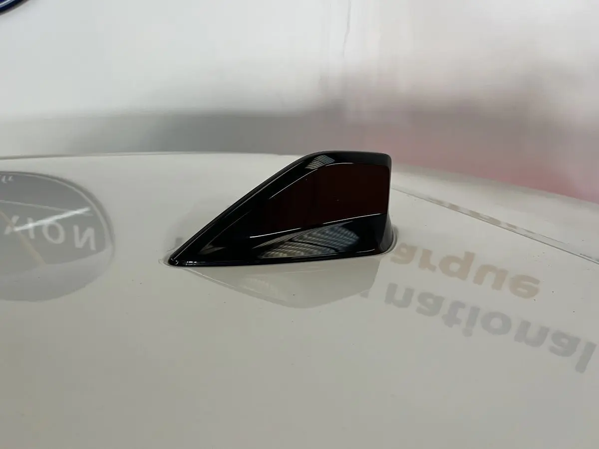 Antenne requin noire en gros plan sur le toit blanc nacré d'une Peugeot 308 GT PHEV 180 Hybride Rechargeable 2022.