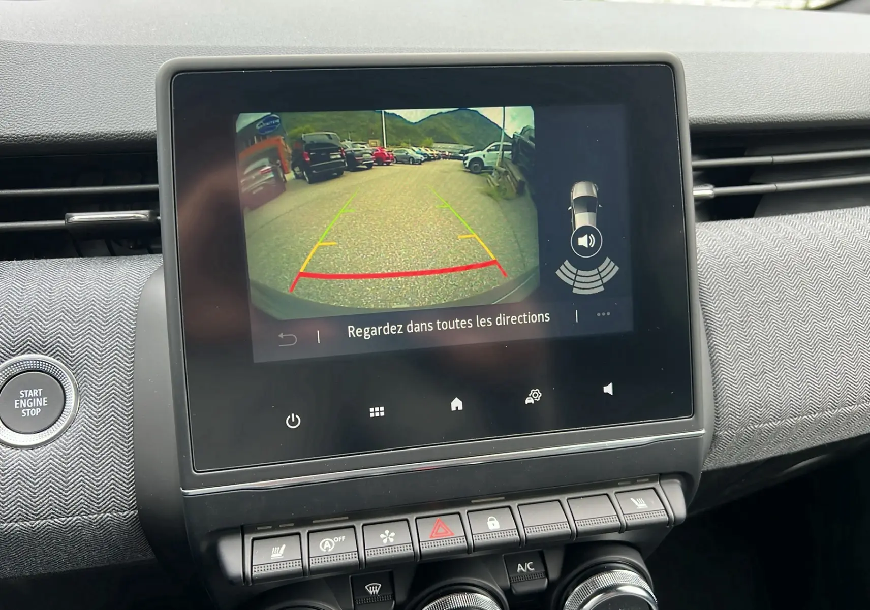 Écran central de la Renault Clio V TCE 90 Techno 2025 montrant la caméra de recul avec lignes de guidage colorées.