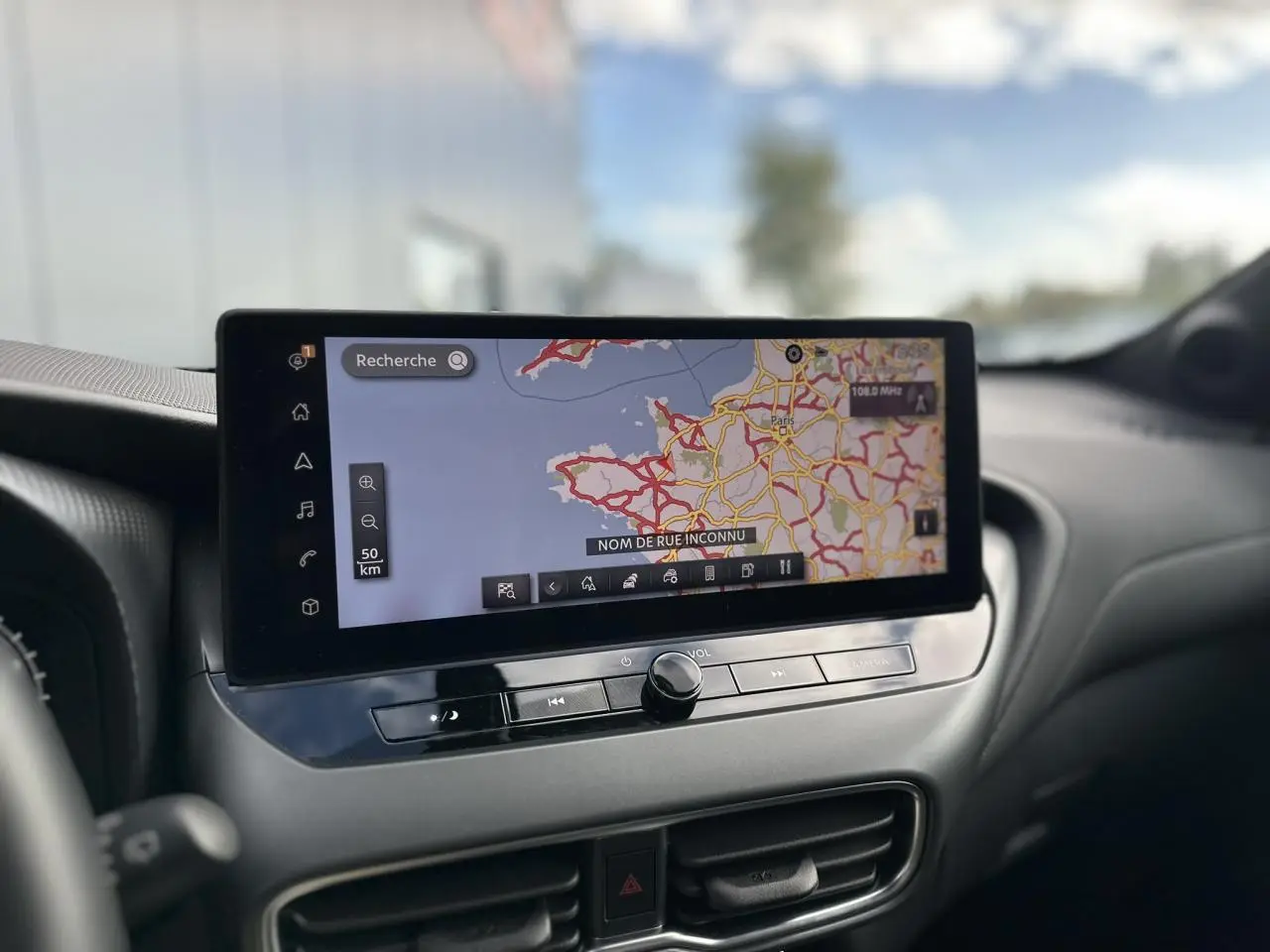 Écran tactile central affichant la navigation GPS dans l'habitacle du Nissan Juke blanc nacré 2025.