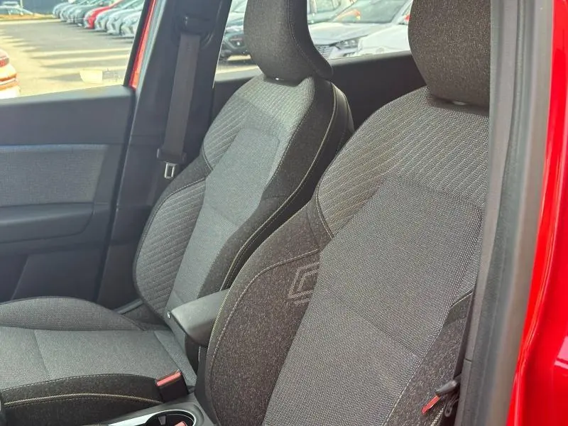 Vue intérieure côté gauche montrant les sièges avant gris foncé du Renault Captur Rouge Flamme 2025 avec portière ouverte.