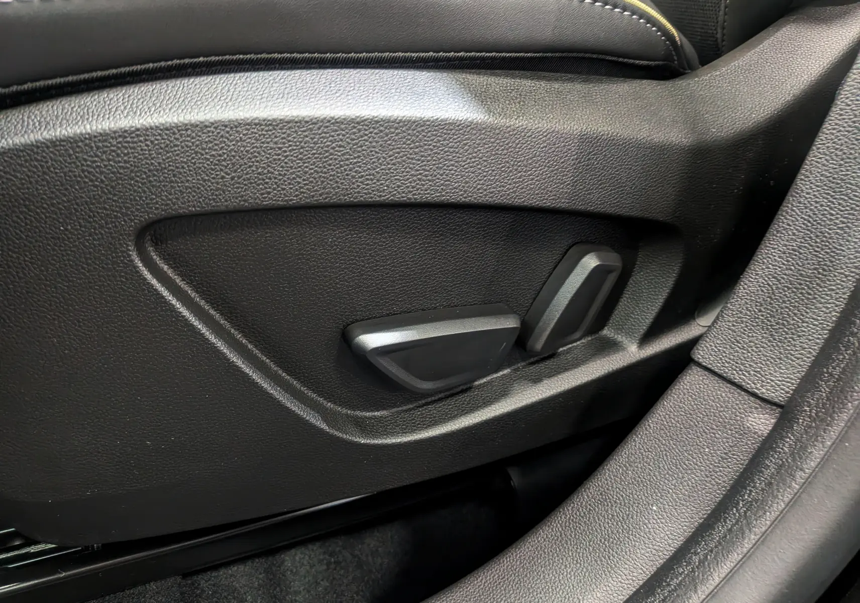 Détail des commandes de réglage électrique du siège conducteur en cuir noir du Renault Symbioz E-Tech 2026.