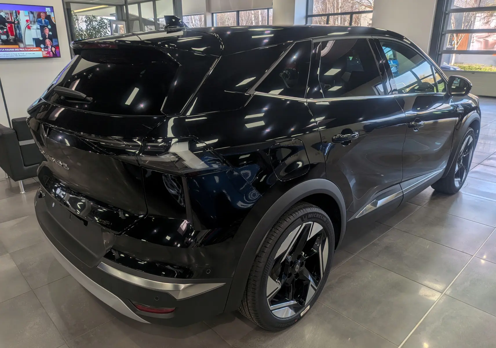 Vue 3/4 arrière droite du Renault SYMBIOZ noir étoilé, soulignant ses jantes bicolores et ses lignes modernes.