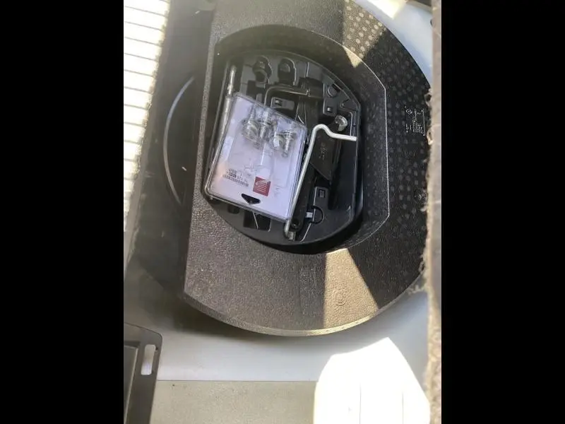 Gros plan sur le rangement sous le coffre du Citroën C3 Aircross blanc 2019, montrant les outils de dépannage.