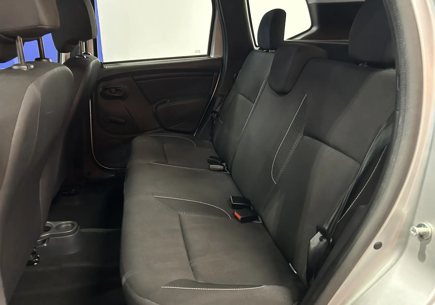 Vue intérieure côté droit des sièges arrière en tissu noir du Dacia Duster gris 2017 version Silver Line.