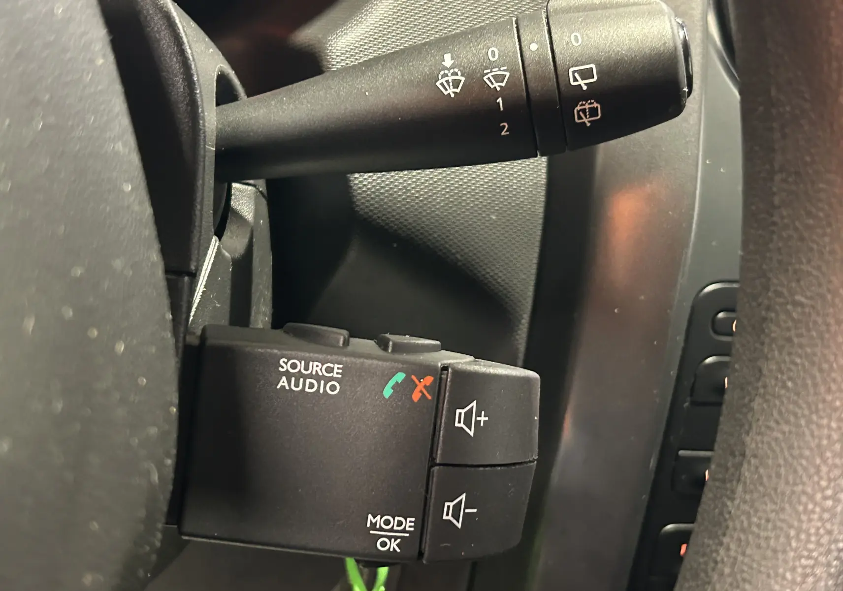 Commande audio au volant côté gauche du Dacia Duster gris 2017, avec boutons de volume et gestion d'appels.