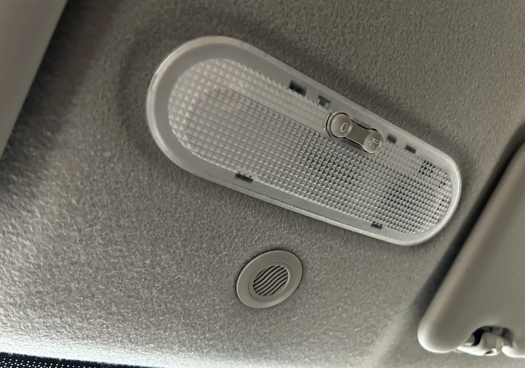 Plafonnier intérieur gris avec interrupteur, sur le toit d'un Dacia Duster gris 2017 version Silver Line.