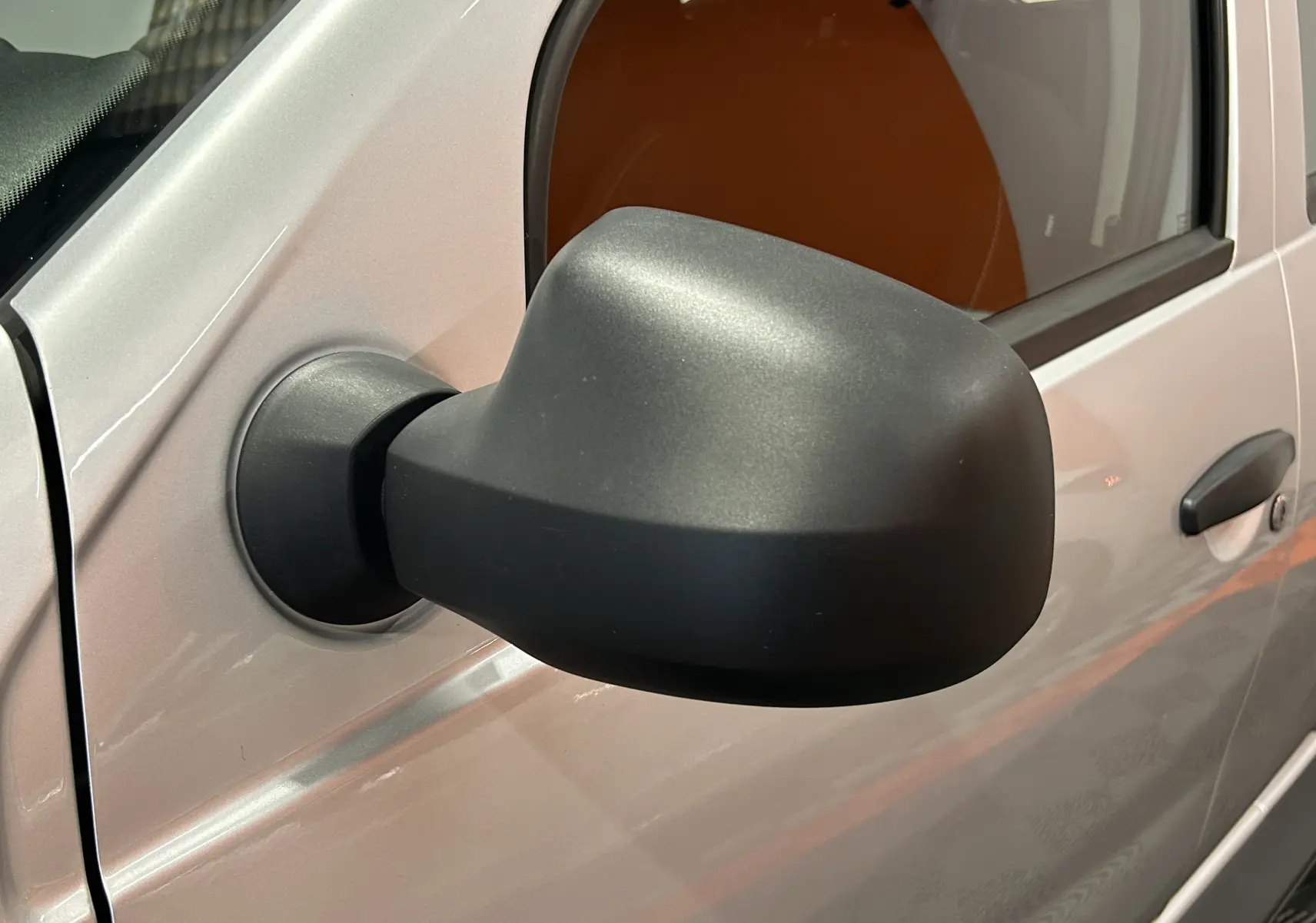 Gros plan sur le rétroviseur côté gauche d'un Dacia Duster gris 2017, mettant en valeur la texture mate du plastique.