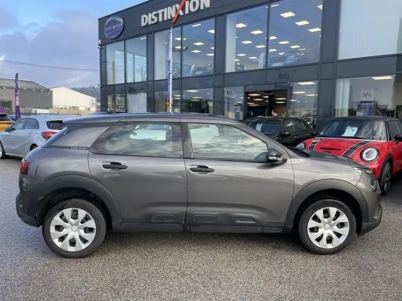 Profil côté gauche d'une Citroën C4 Cactus 2019 gris foncé métal, avec protections latérales caractéristiques et jantes simples.