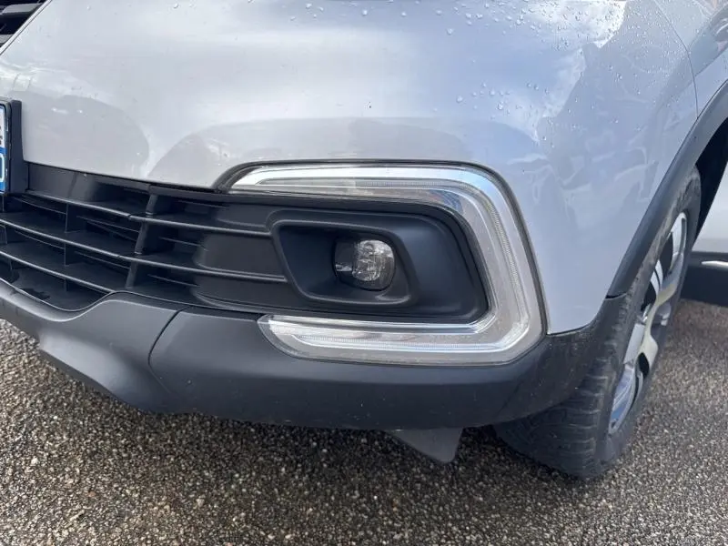 Gros plan sur le phare antibrouillard avant droit du Renault Captur gris platine avec jante alliage visible.