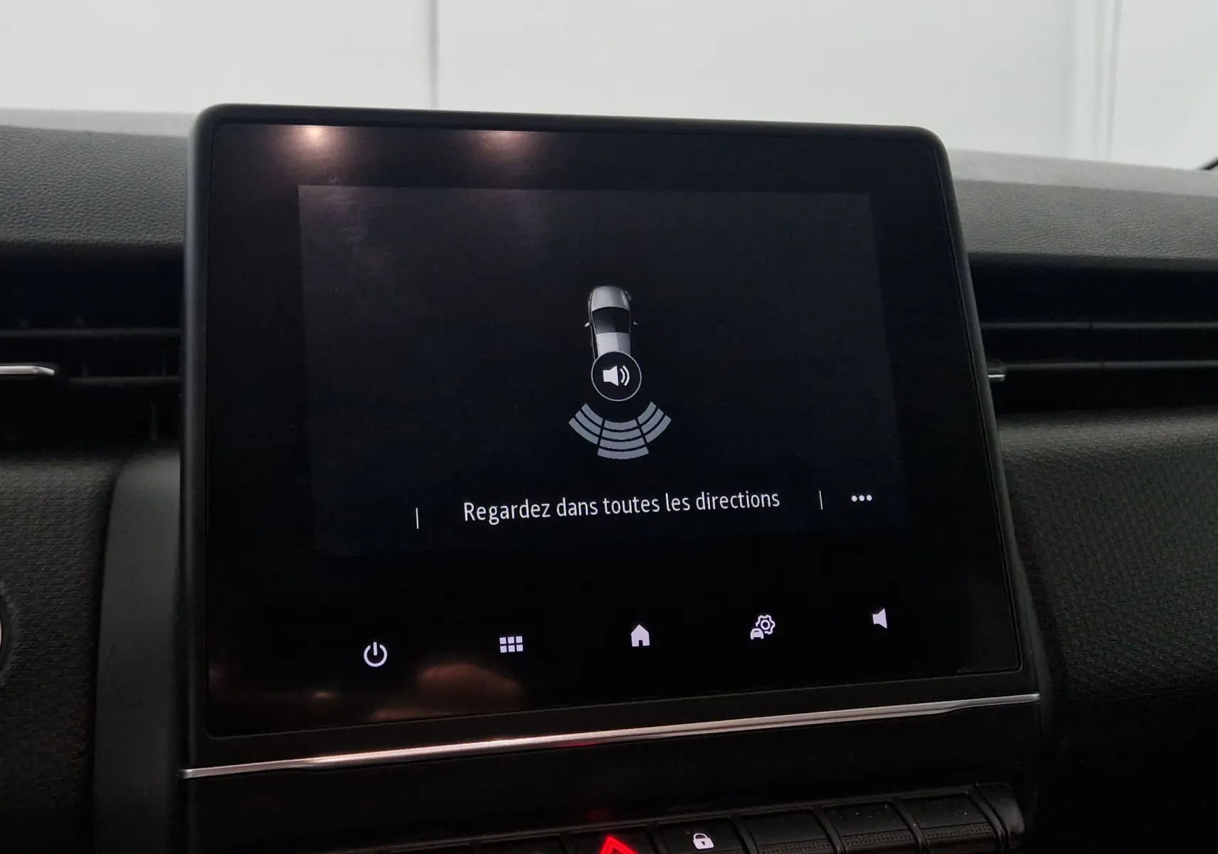 Écran tactile central de la Renault Clio V gris platine affichant l'alerte de surveillance des angles morts.