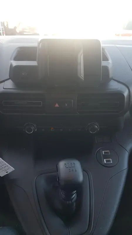 Vue intérieure centrée sur la console centrale et levier de vitesse manuel du Citroën Berlingo blanc 2025.