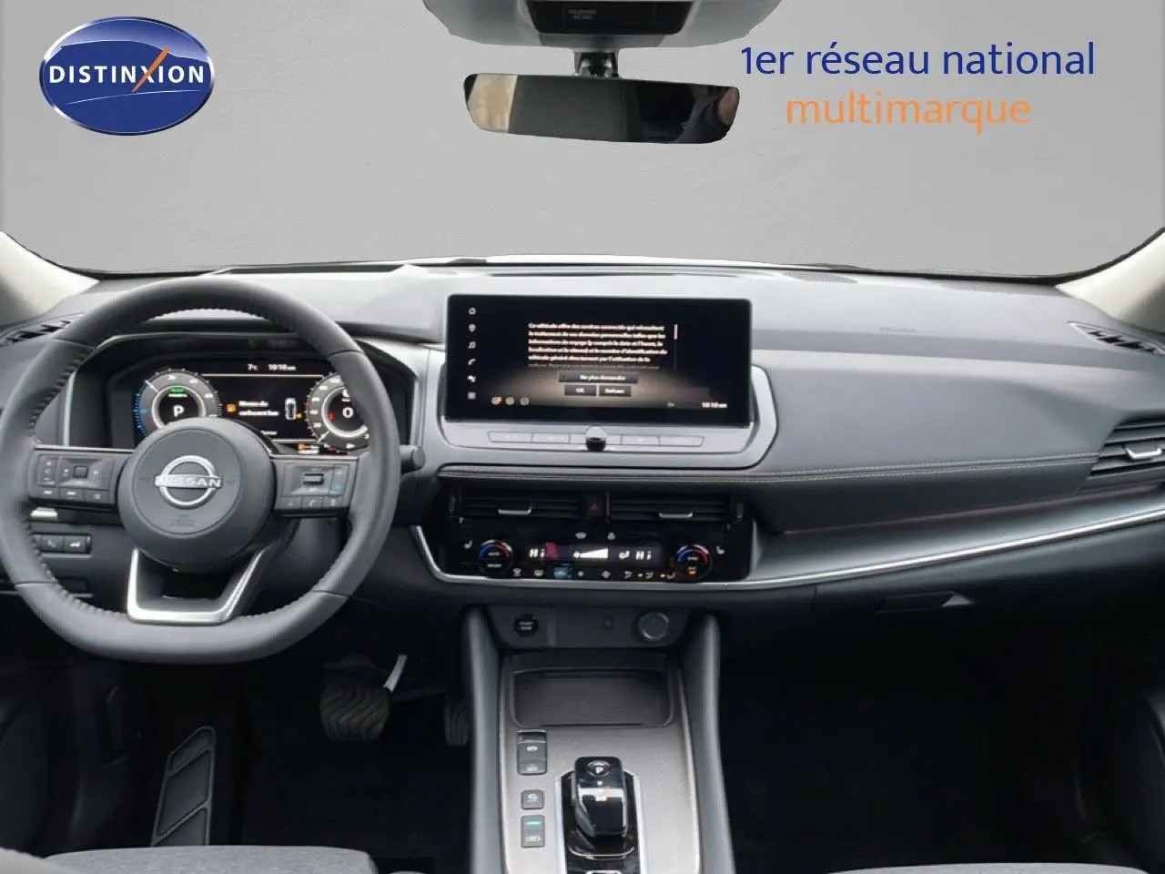 Vue intérieure du tableau de bord du Nissan Qashqai blanc nacré, avec écran tactile central et volant multifonction.