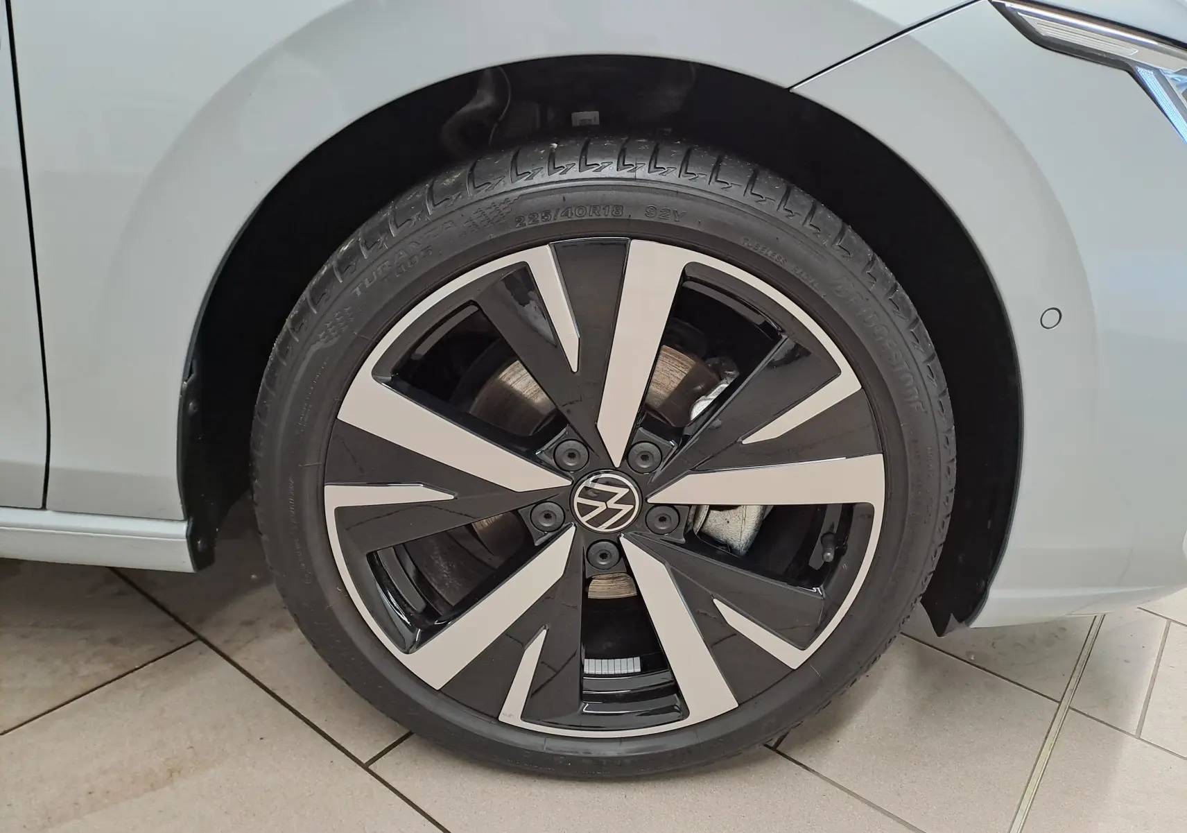 Gros plan sur la jante alliage 18'' Catania bicolore noir et argent de la Volkswagen Golf 1.5 eTSI 116 BVM6 Argent Dolomite.