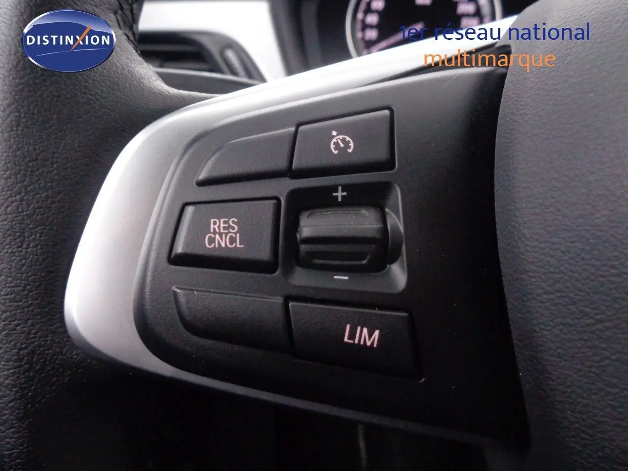 Gros plan sur les commandes de régulateur de vitesse au volant d'un BMW X1 blanc Alpine Metal de 2022.