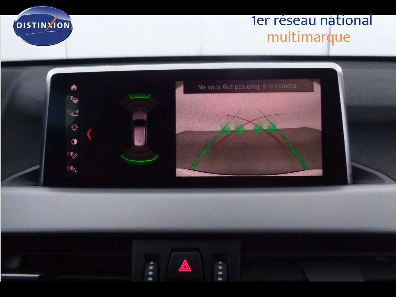 Écran central du BMW X1 2022 montrant la caméra de recul et les capteurs de stationnement actifs.